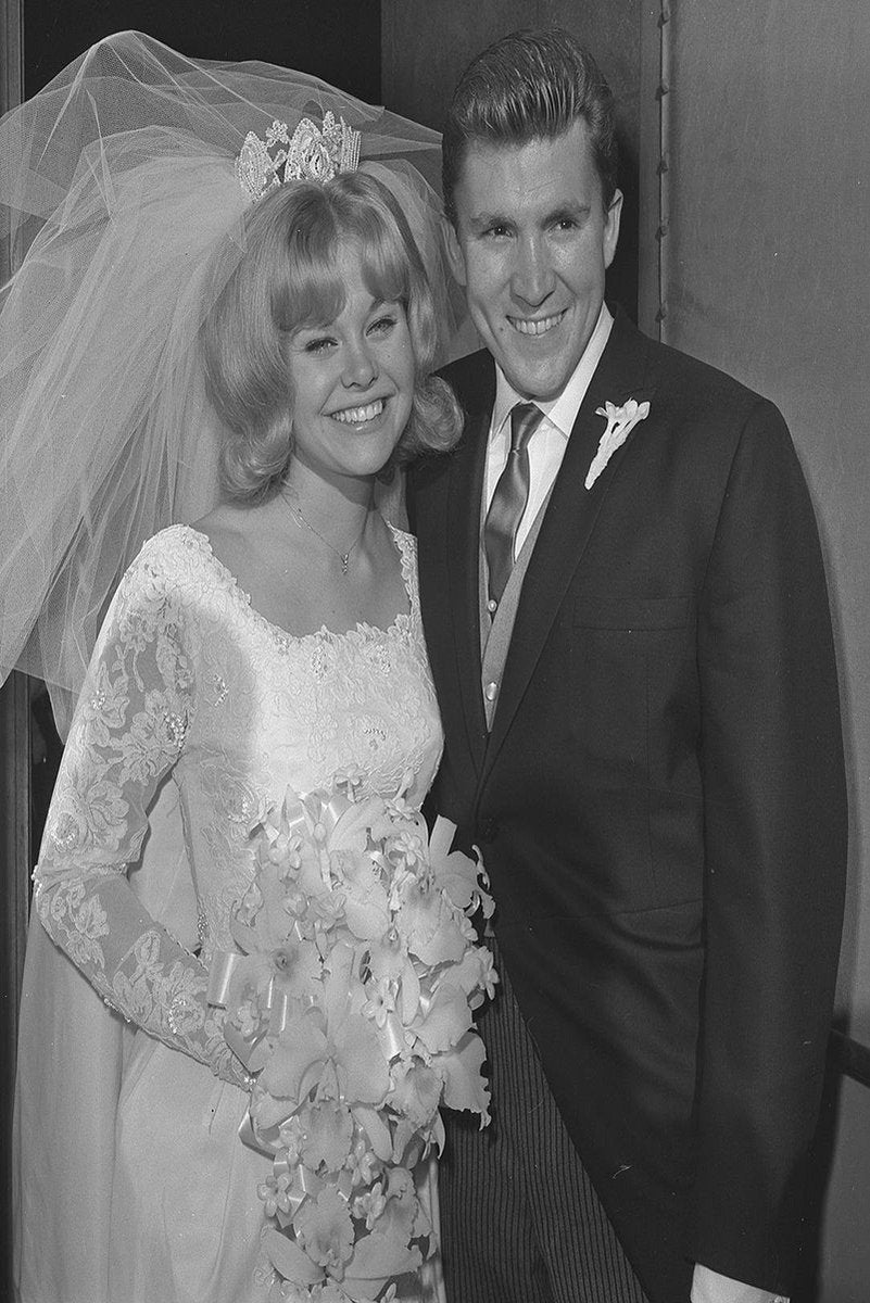 Kenny Lynch wedding poster features the smiling groom beside his bride in a lace gown, veil, tiara, and cascading bouquet.