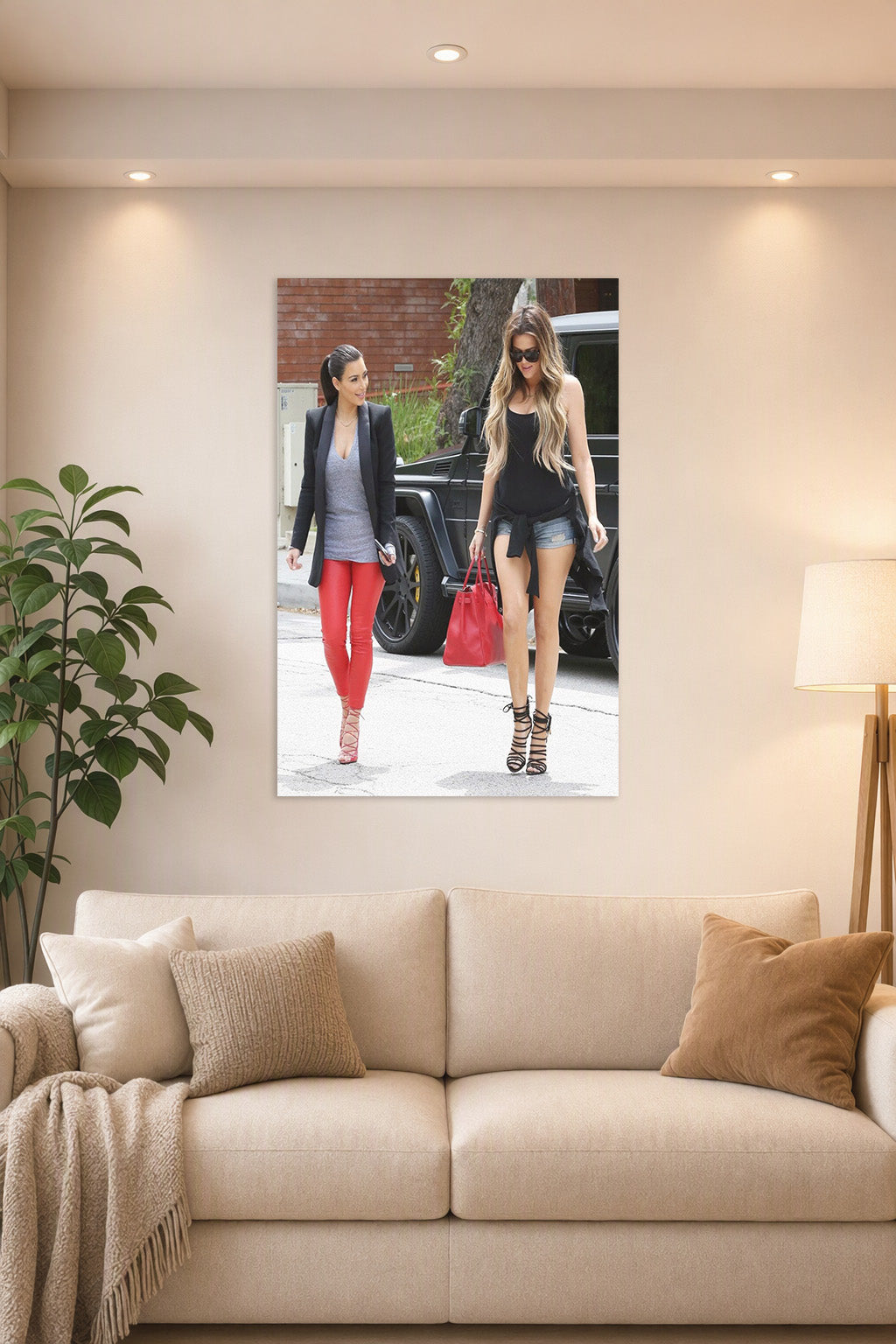 Kim and Khloé Kardashian in a bright living room above a beige sofa.