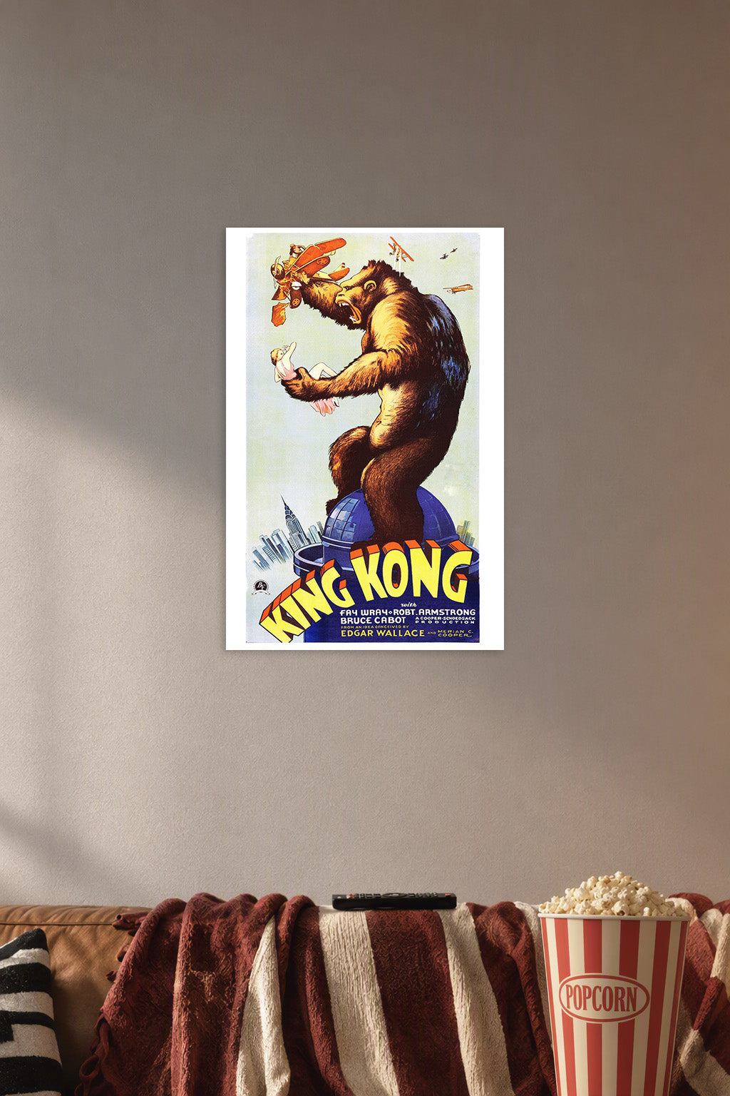 King Kong in a cozy movie room above a brown sofa with popcorn.