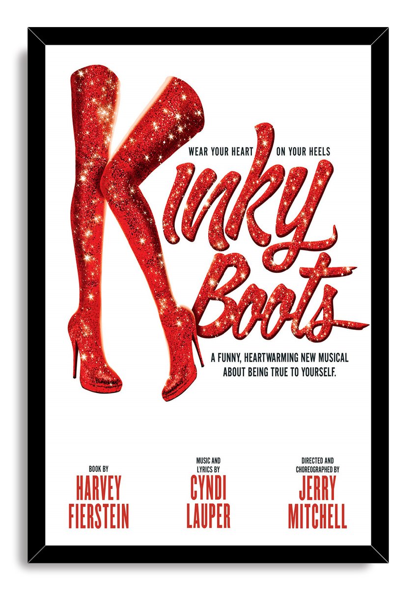 Kinky Boots framed wall art print with a black border, glittering red thigh-high boots, red script title, and white background.