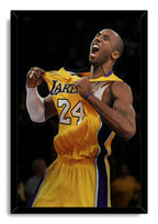 Kobe Bryant framed wall art print portrays the player yelling as he pulls his yellow Lakers number 24 jersey, set in a black frame.