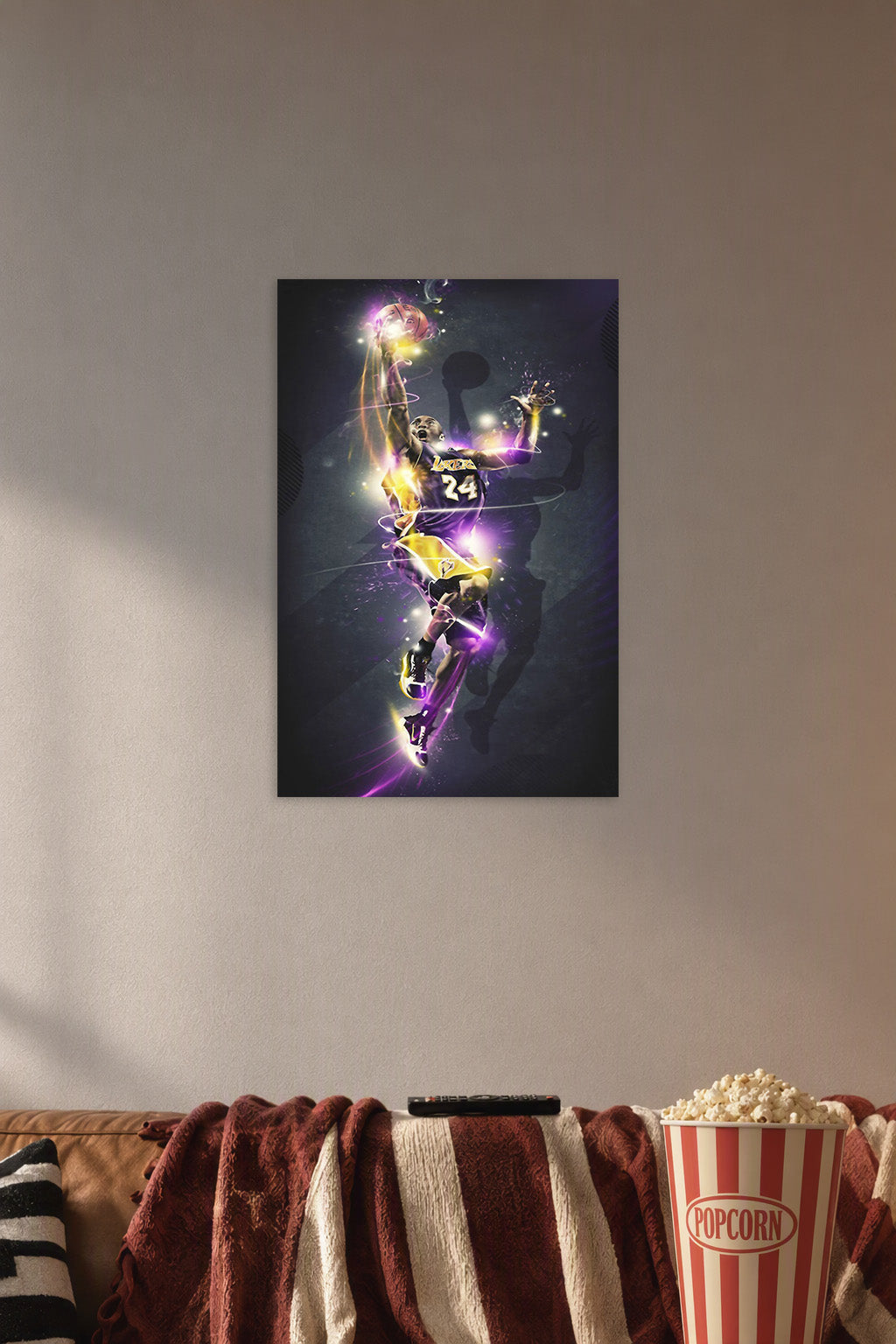 Kobe Bryant in a cozy movie room above a brown sofa with popcorn.
