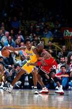 Kobe Bryant and Michael Jordan basketball poster captures Bryant dribbling in a yellow Lakers number 8 jersey as Jordan defends in red, before a packed crowd.