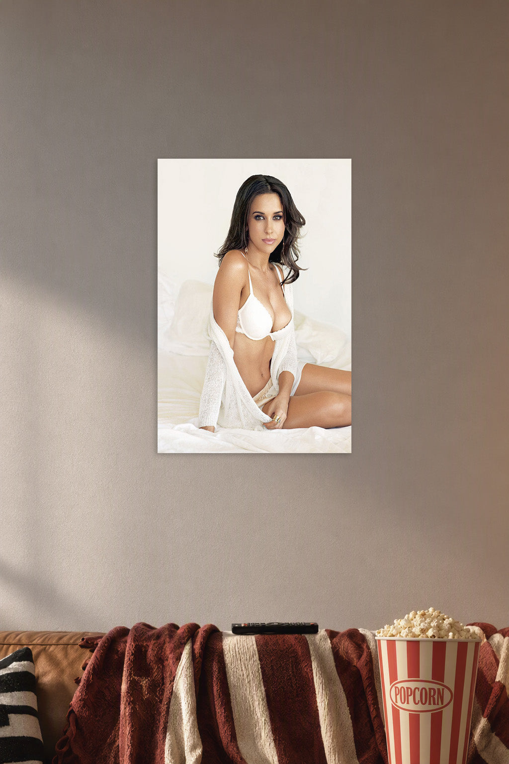 Lacey Chabert in a cozy movie room above a brown sofa with popcorn.