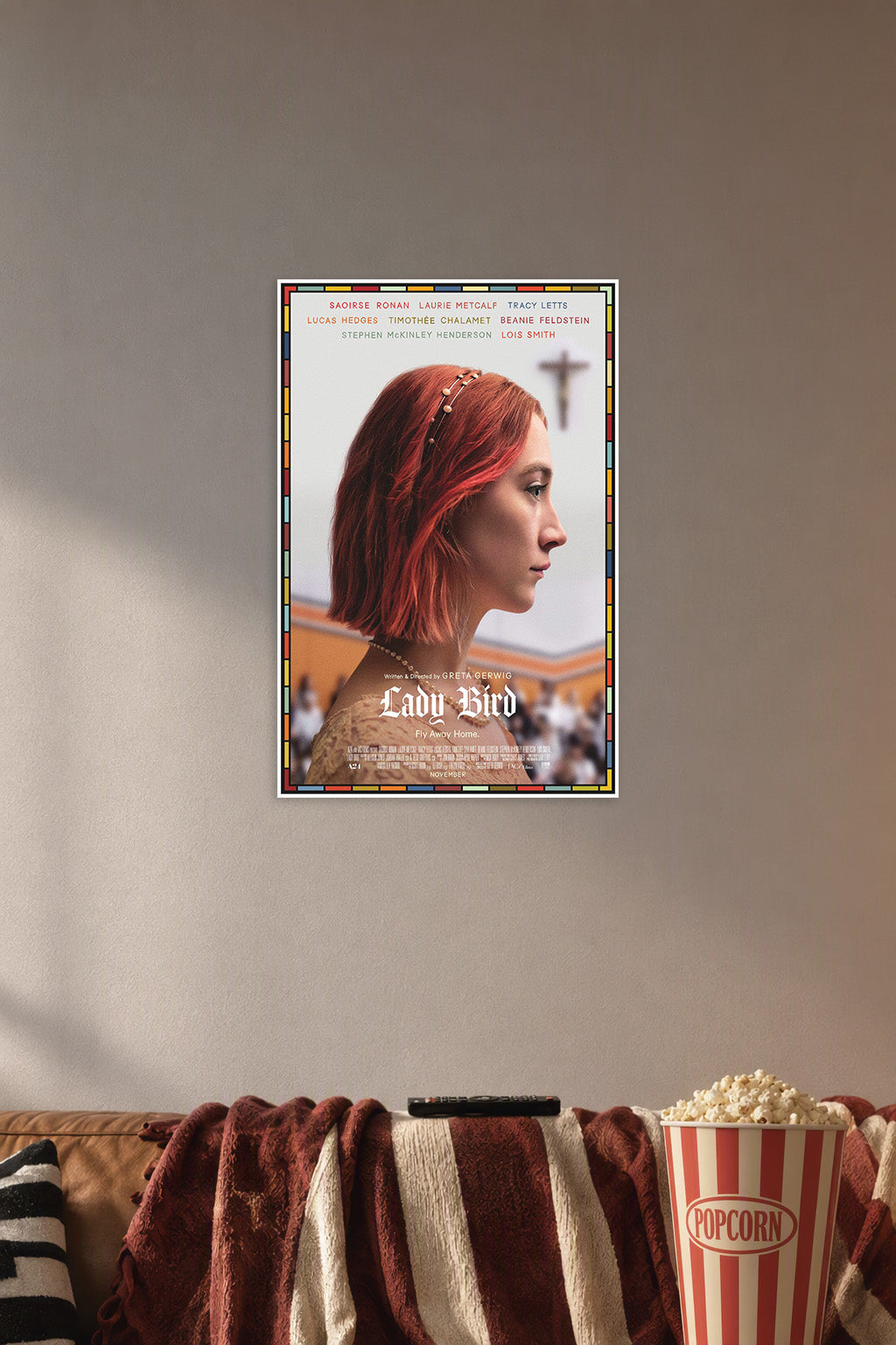 Lady Bird in a cozy movie room above a brown sofa with popcorn.