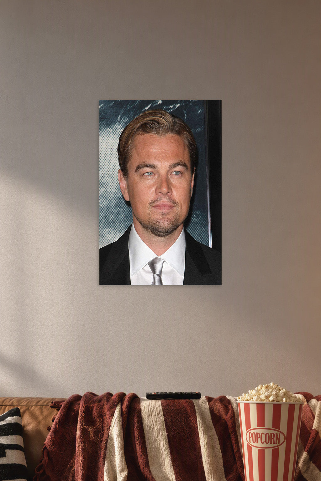 Leonardo DiCaprio in a cozy movie room above a brown sofa with popcorn.
