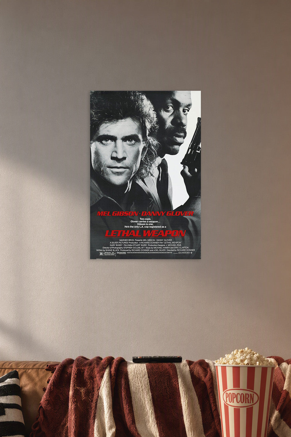 Lethal Weapon Mel Gibson Danny Glover in a cozy movie room above a brown sofa with popcorn.