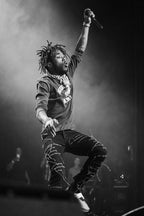 Lil Uzi Vert poster captures the rapper leaping onstage with a raised microphone amid dramatic black-and-white haze.