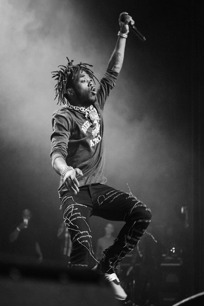 Lil Uzi Vert poster captures the rapper leaping onstage with a raised microphone amid dramatic black-and-white haze.