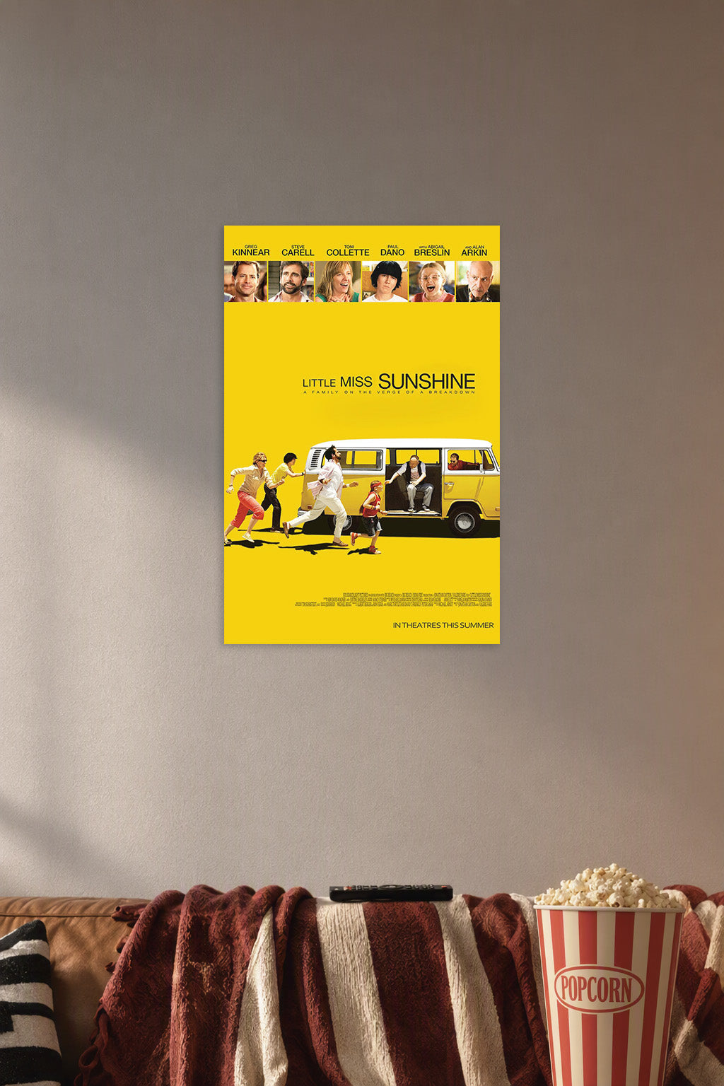 Little Miss Sunshine Movie Poster in a cozy movie room above a brown sofa with popcorn.