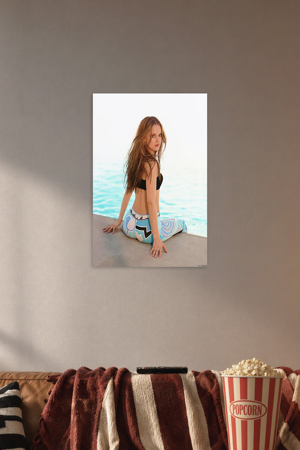 Long-Haired Woman by the Water in a cozy movie room above a brown sofa with popcorn.
