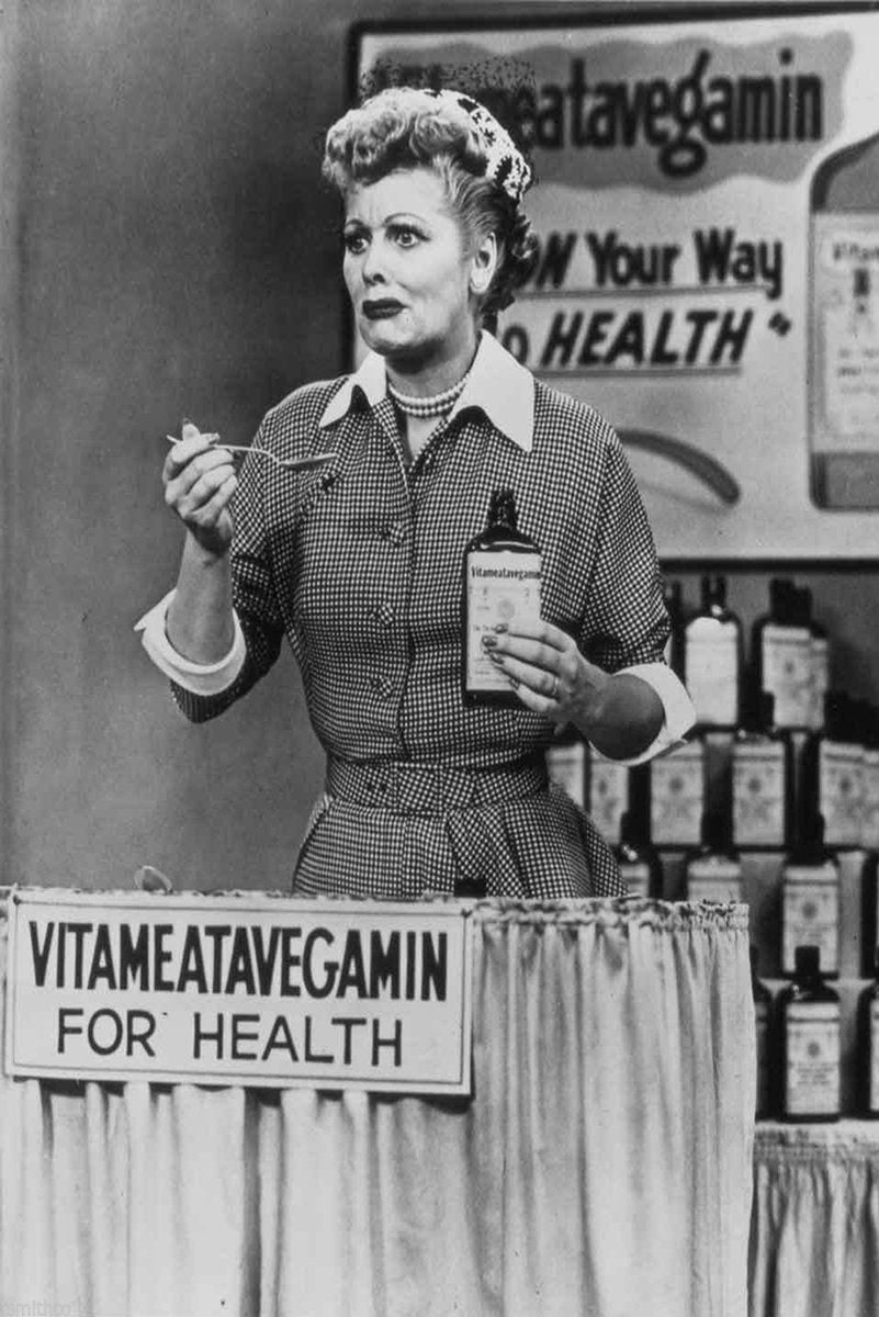 Lucille Ball Vitameatavegamin wall art print in black and white, holding a spoon and tonic bottle behind a health sign.