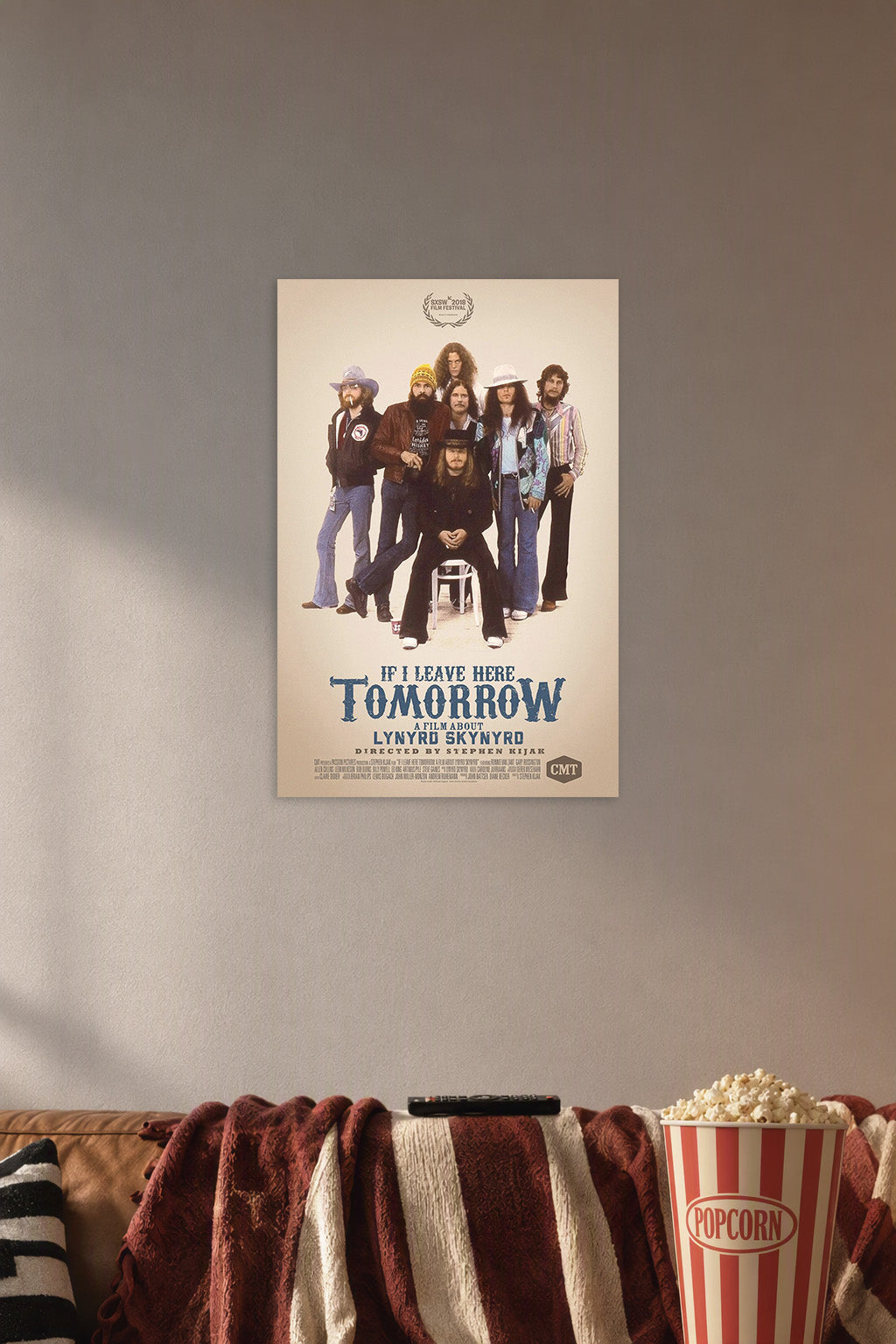 Lynyrd Skynyrd Band 'If I Leave Here Tomorrow' Movie Poster art poster print in a cozy movie room above a brown sofa with popcorn.