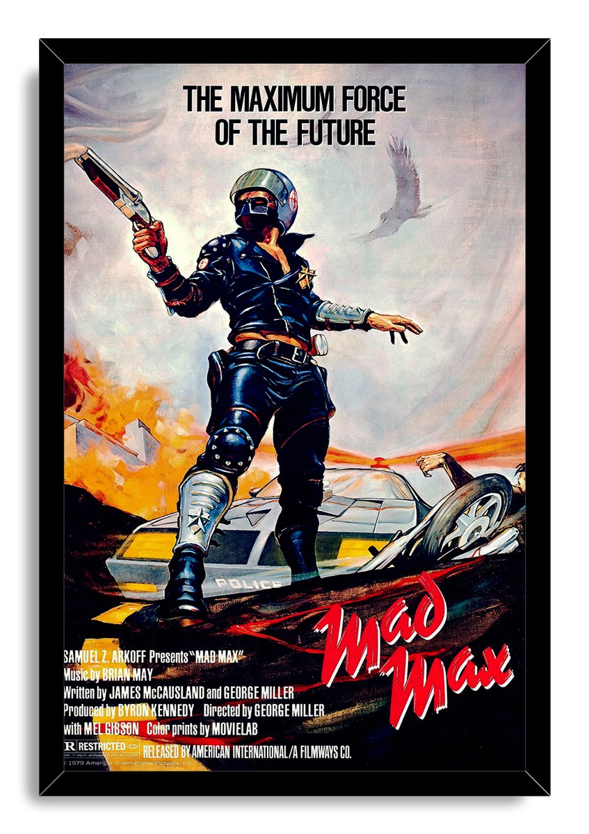 Mad Max framed wall art print with a black frame, depicting an armed leather-clad officer, police car, flames, eagle, and wreckage.