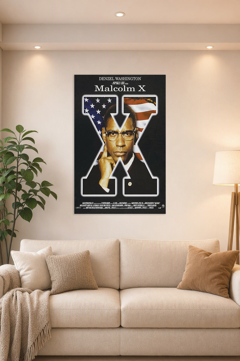 Malcolm X in a bright living room above a beige sofa.