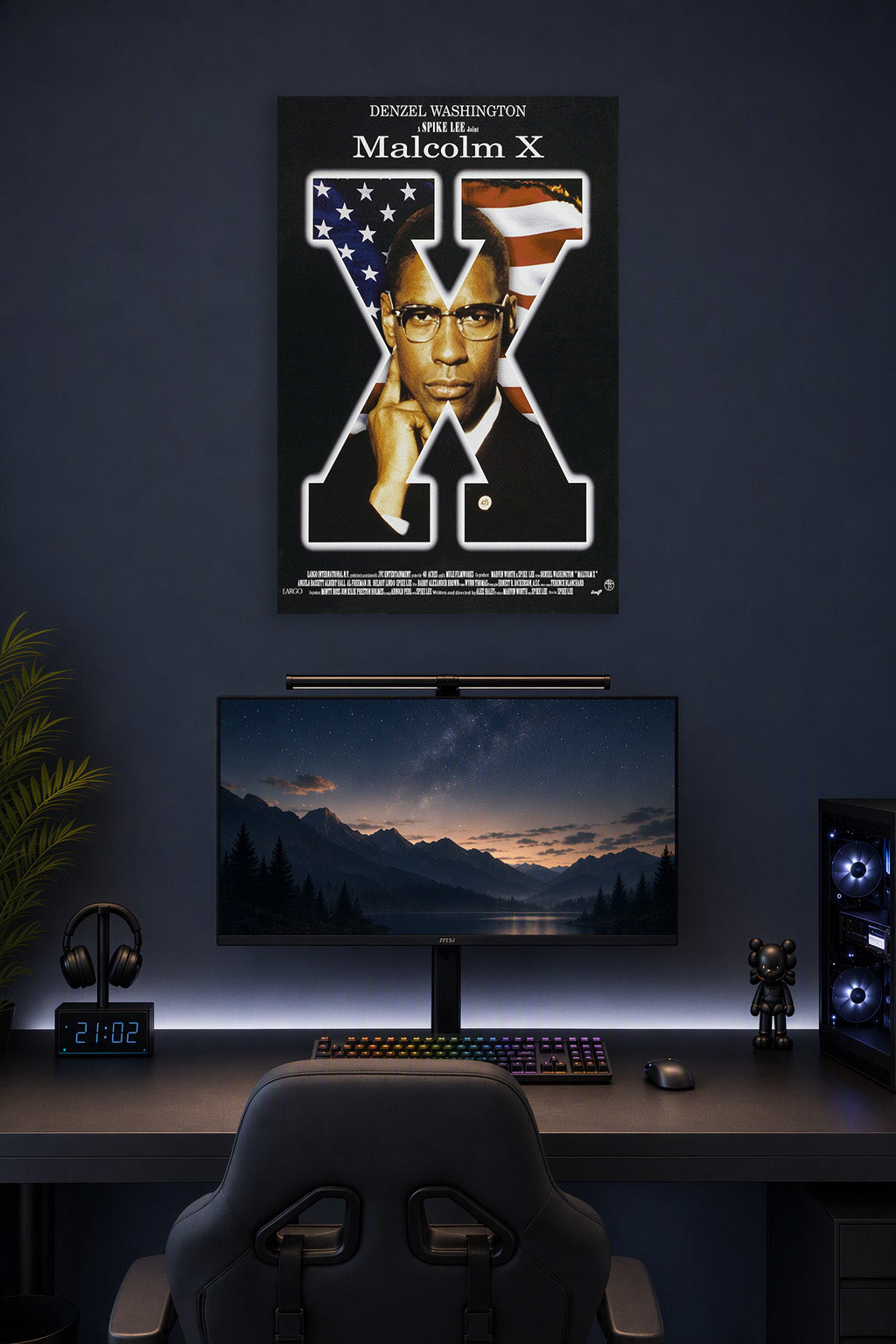 Malcolm X Movie Poster in a gaming desk setup above a monitor.