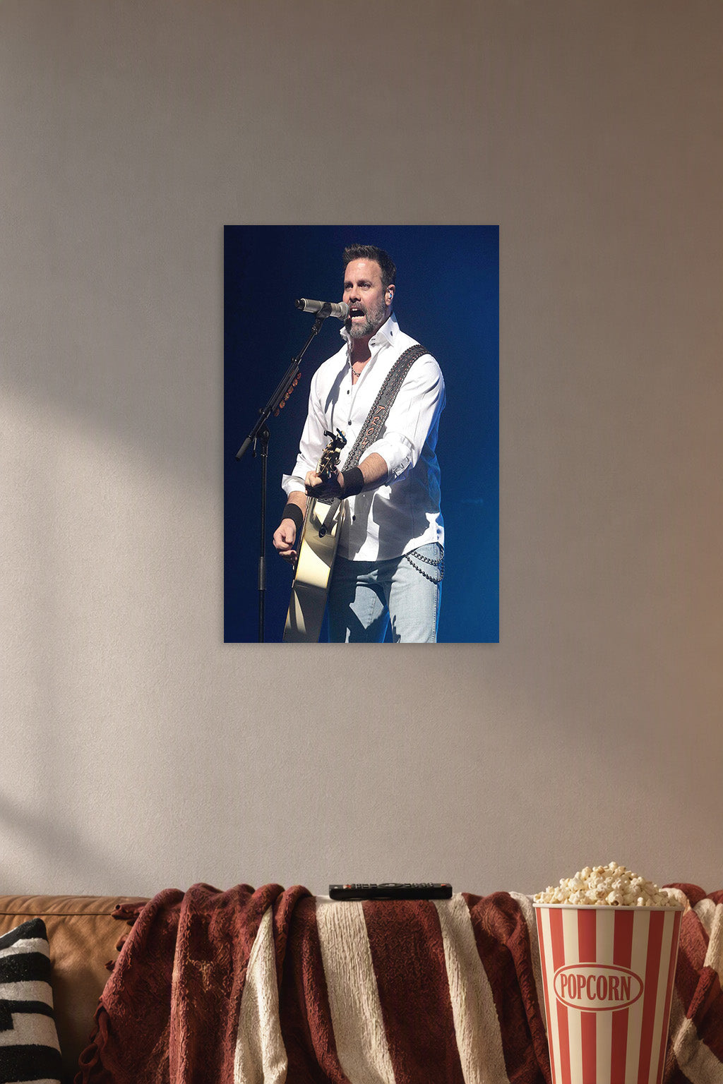 Male Singer Performing in a cozy movie room above a brown sofa with popcorn.