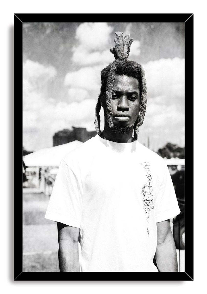 Framed wall art print with a black border, portraying a man with dreadlocks in a white T-shirt beneath clouds.