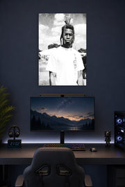 Man with Dreadlocks in a gaming desk setup above a monitor.