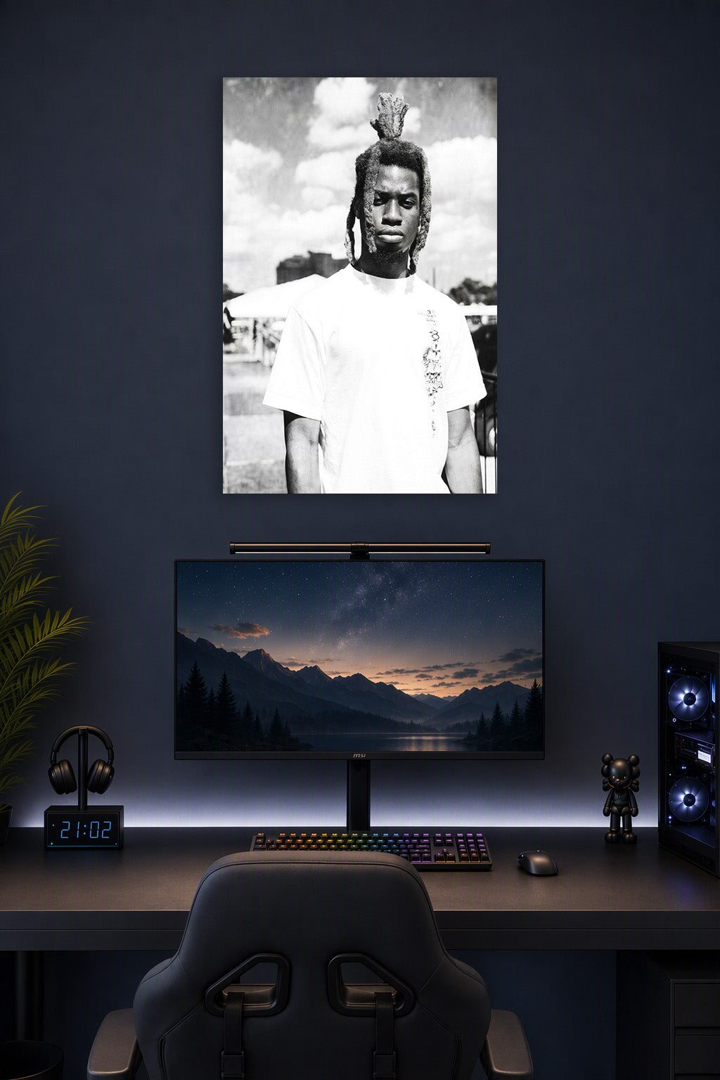 Man with Dreadlocks in a gaming desk setup above a monitor.