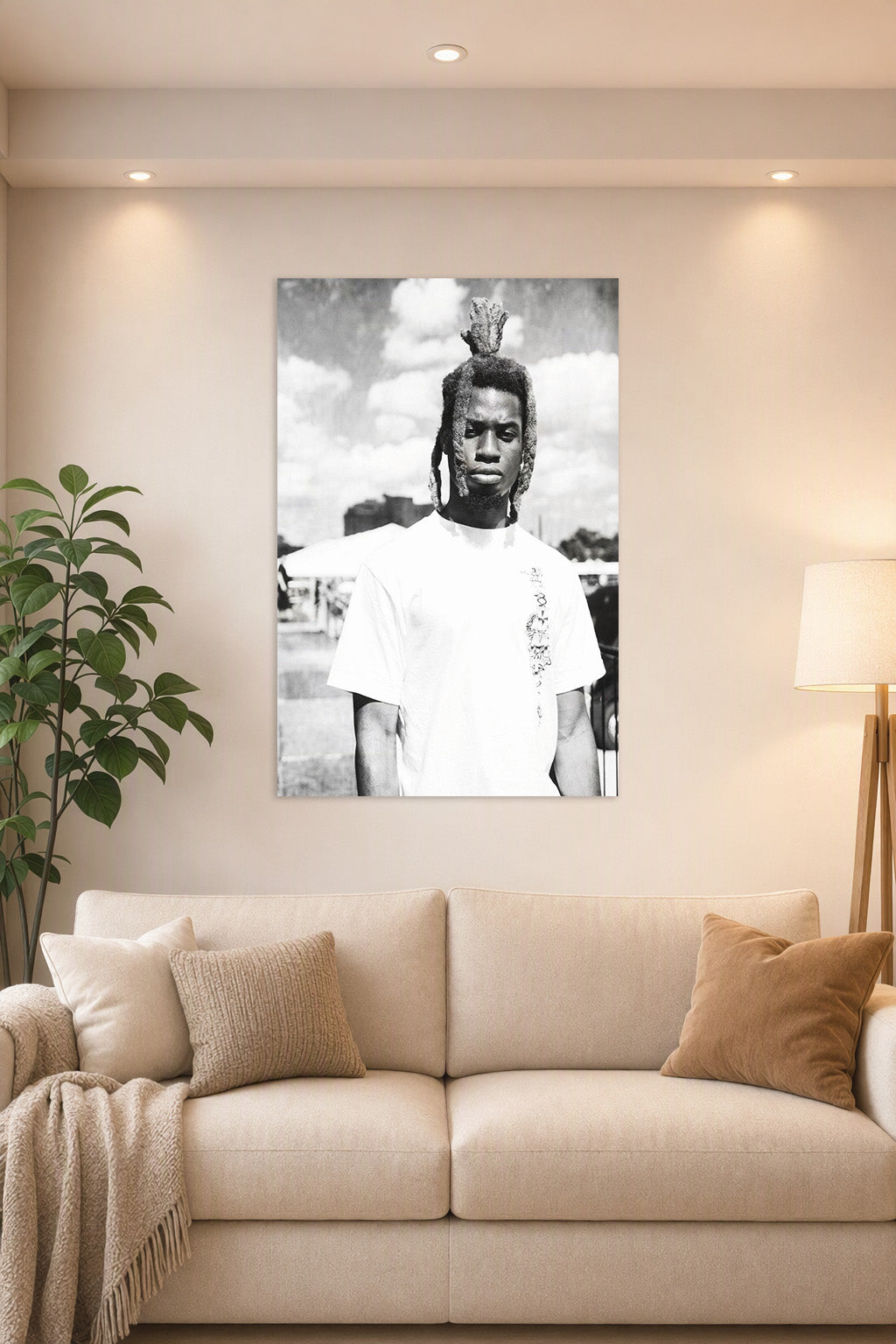 Man with Dreadlocks in a bright living room above a beige sofa.