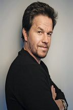 Mark Wahlberg poster portrait with the actor in a black sweater, arms crossed, against a soft gray background.