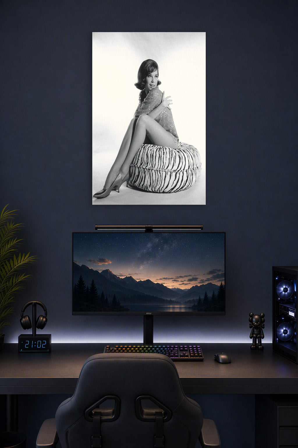 Mary Tyler Moore in a gaming desk setup above a monitor.