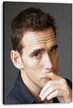 Matt Dillon canvas wall art print featuring a close-up portrait, thoughtful gaze, dark shirt, and deep gray backdrop.