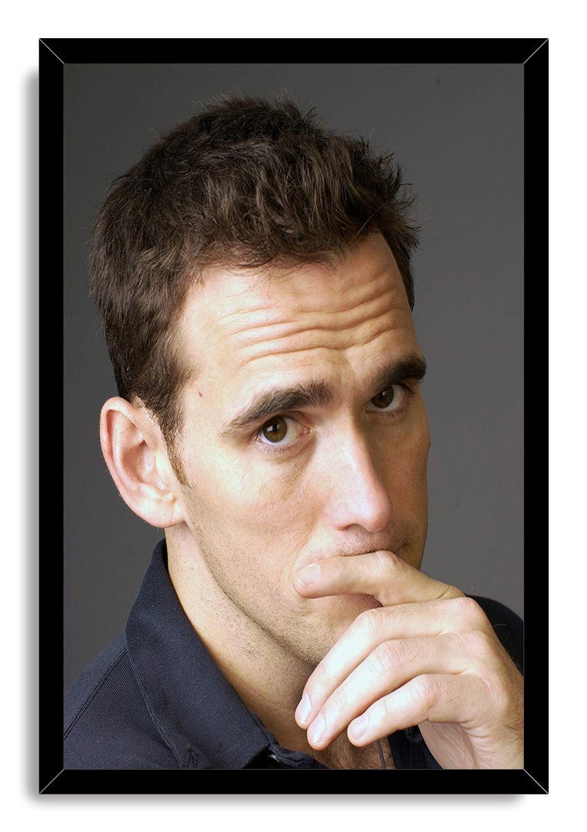Matt Dillon framed wall art print with a black border, depicting his pensive close-up portrait against a dark gray background.