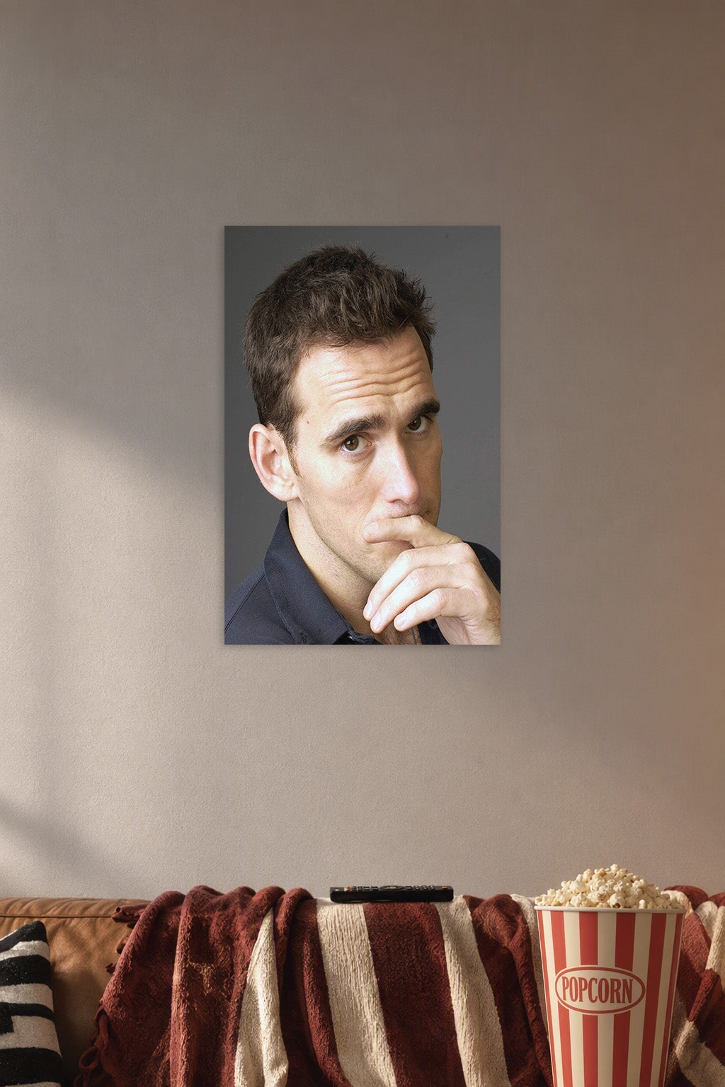 Matt Dillon in a cozy movie room above a brown sofa with popcorn.