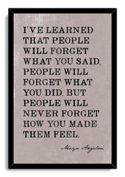 Maya Angelou quote wall art print in a black mitered frame, featuring distressed black typography on a pale gray background.
