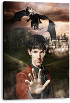 Merlin canvas wall art print depicts a young man with an outstretched hand, dragon, green hills, and a distant castle.