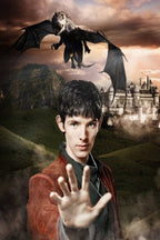 Merlin wall art print portrays a young dark-haired man raising his hand beneath a flying dragon and castle at dusk.