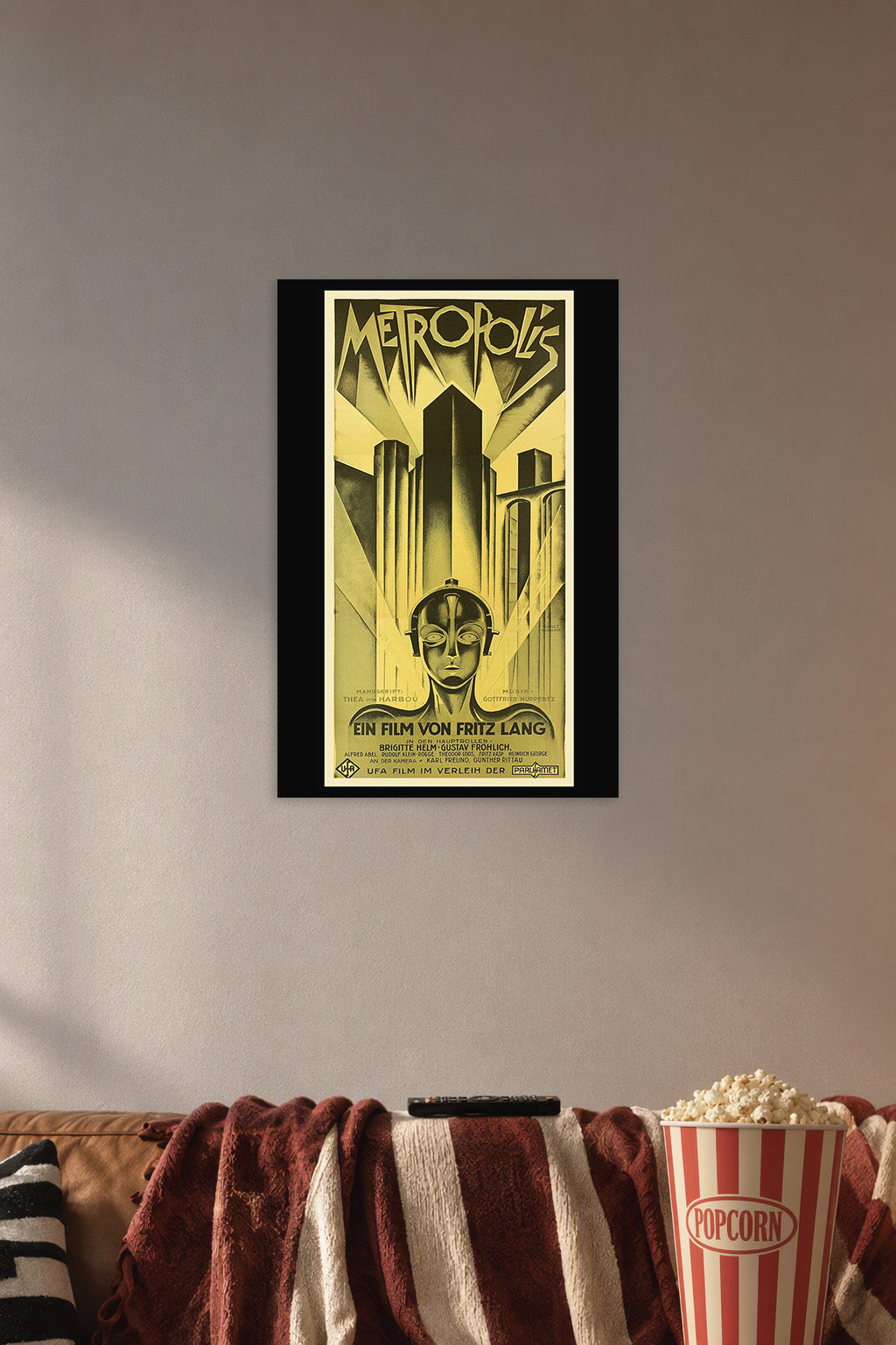 Metropolis Movie Poster in a cozy movie room above a brown sofa with popcorn.