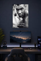 Mike Tyson in a gaming desk setup above a monitor.