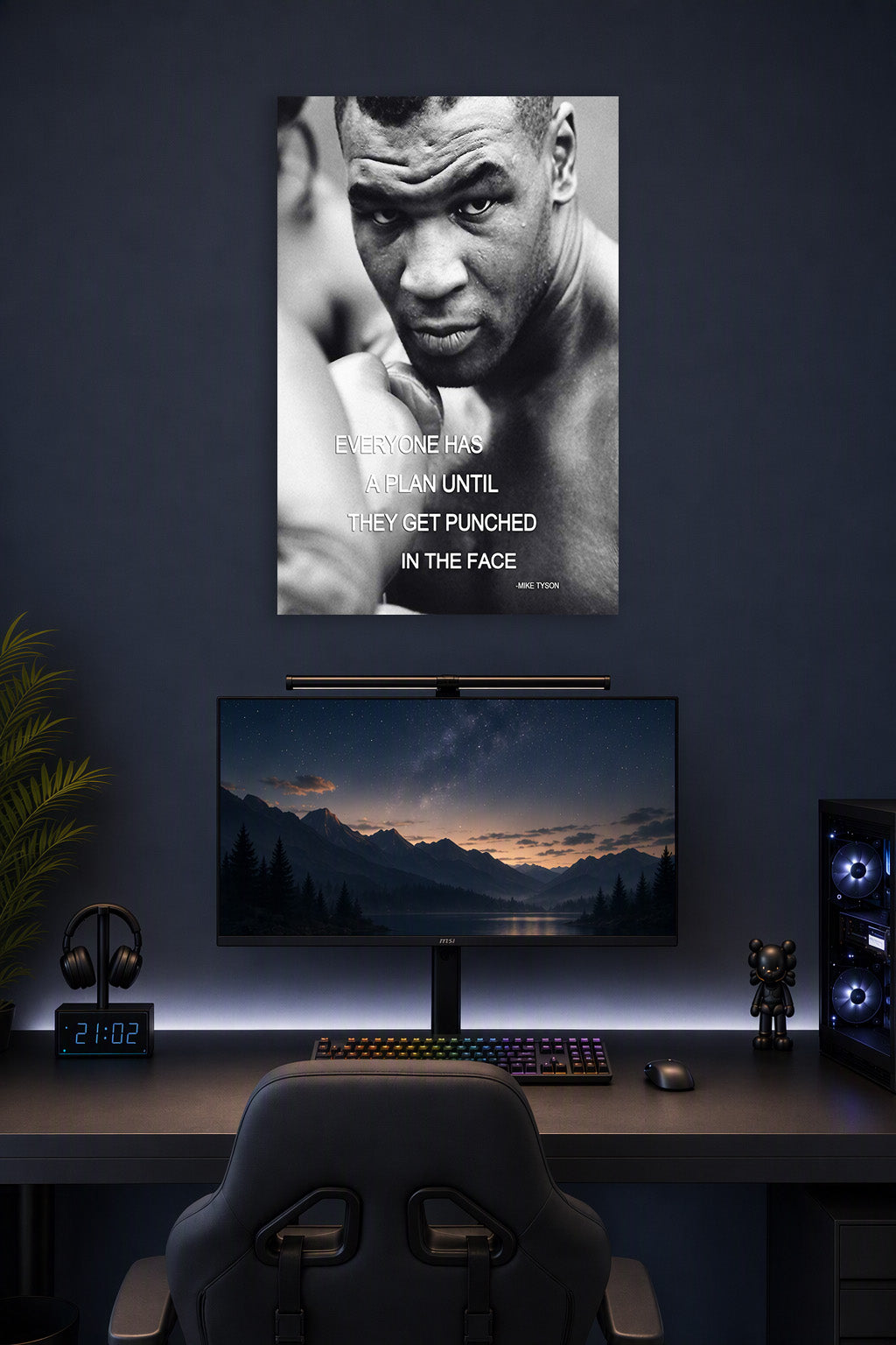 Mike Tyson in a gaming desk setup above a monitor.