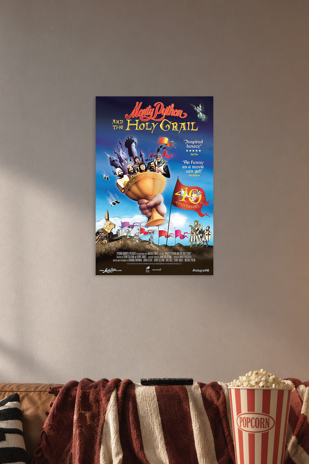 Monty Python and the Holy Grail Movie Poster in a cozy movie room above a brown sofa with popcorn.