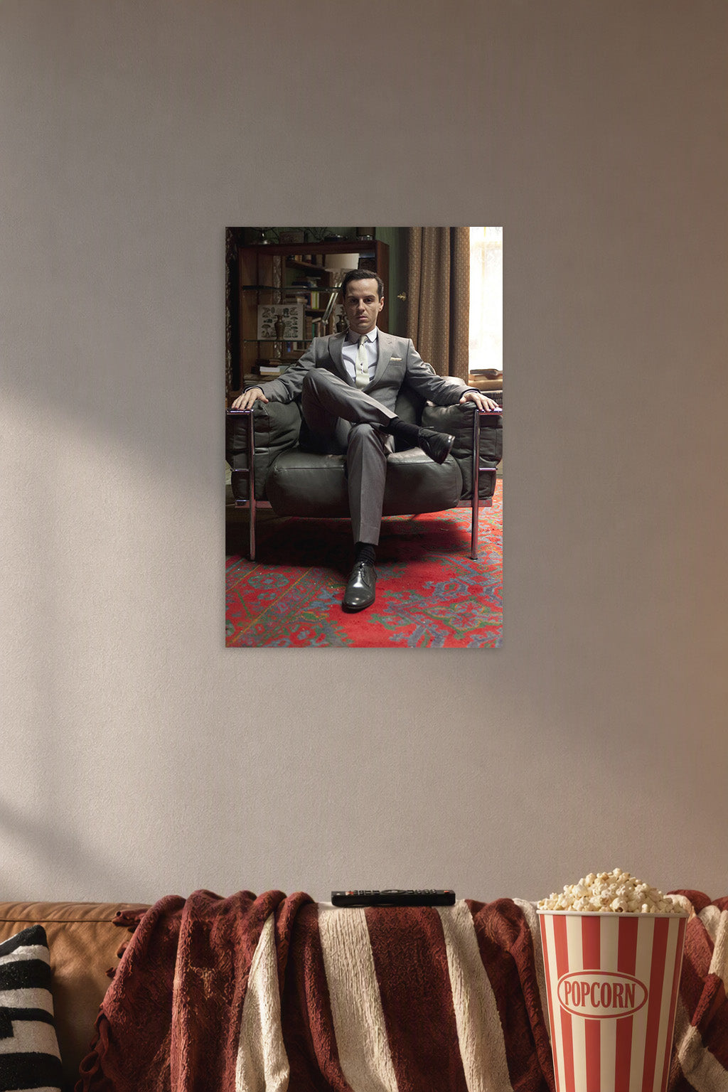Moriarty (Andrew Scott) from Sherlock in a cozy movie room above a brown sofa with popcorn.