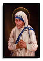 Mother Teresa framed wall art print depicts a warm portrait with clasped hands, rosary beads, blue-trimmed habit, and halo.