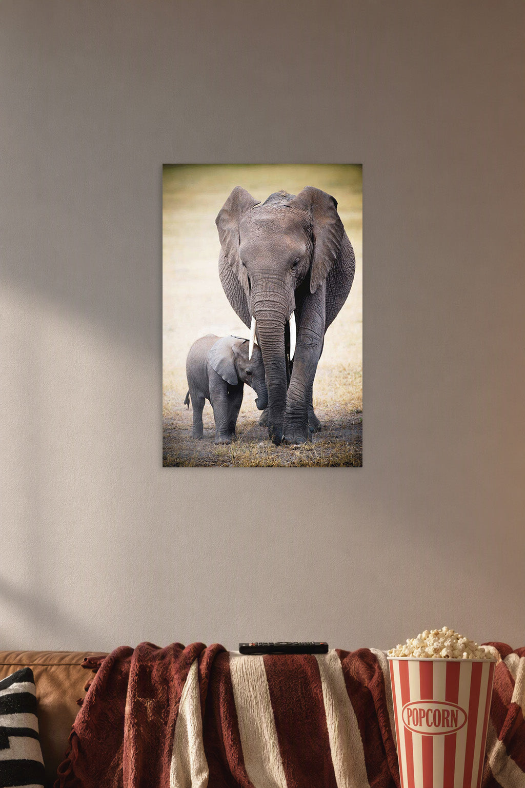Mother and Baby Elephant in a cozy movie room above a brown sofa with popcorn.