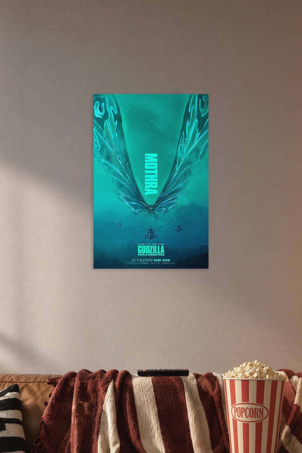 Mothra in a cozy movie room above a brown sofa with popcorn.