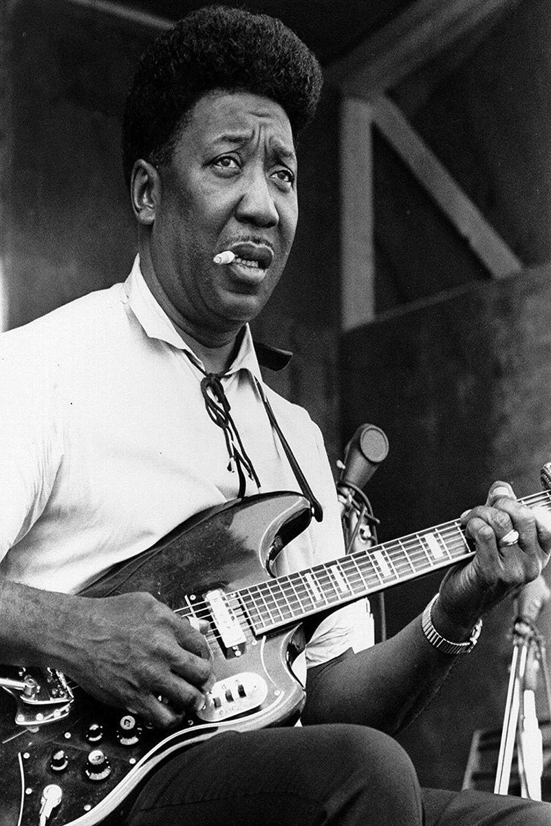 Muddy Waters wall art print in black and white, capturing the blues musician playing an electric guitar with a cigarette.