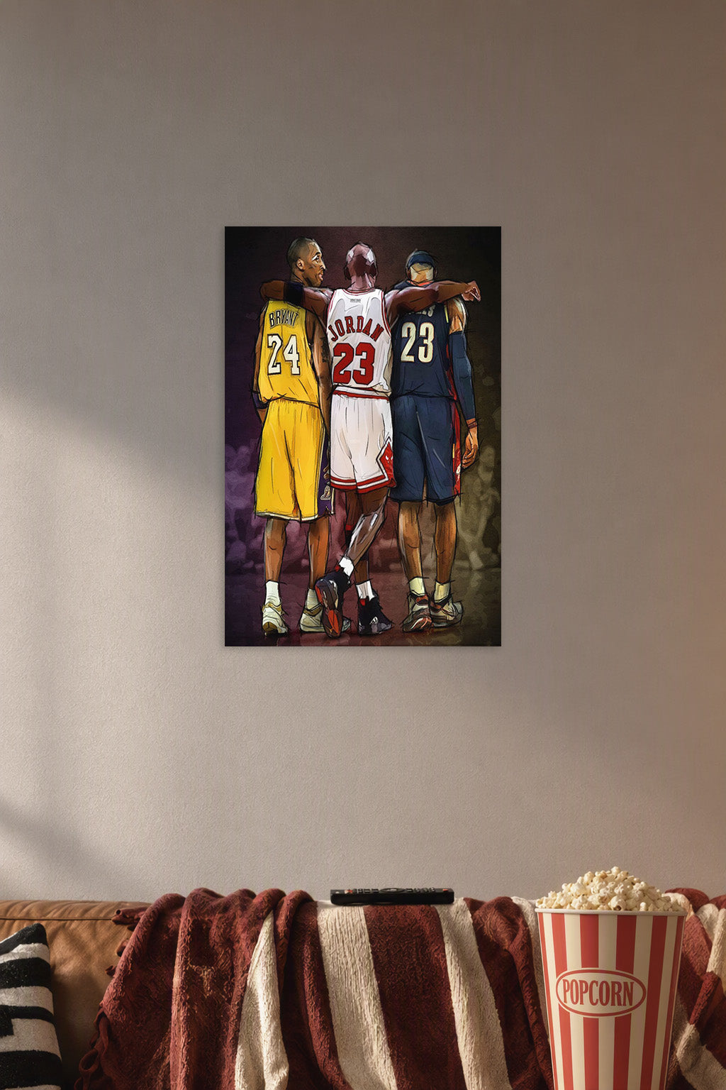NBA Legends Kobe Jordan LeBron in a cozy movie room above a brown sofa with popcorn.