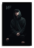 NF framed wall art print depicts the rapper seated in a dark hoodie and cap, with a subtle NF logo at the upper left.