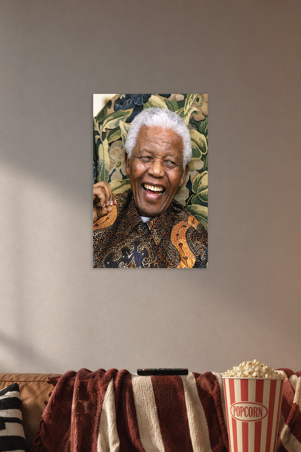 Nelson Mandela in a cozy movie room above a brown sofa with popcorn.