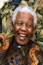 Nelson Mandela poster features a close-up of him laughing in a black and orange patterned shirt before floral upholstery.