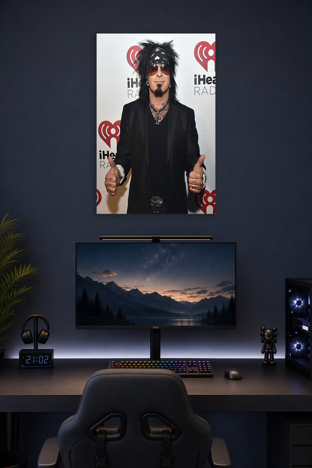 Nikki Sixx (Mötley Crüe) in a gaming desk setup above a monitor.