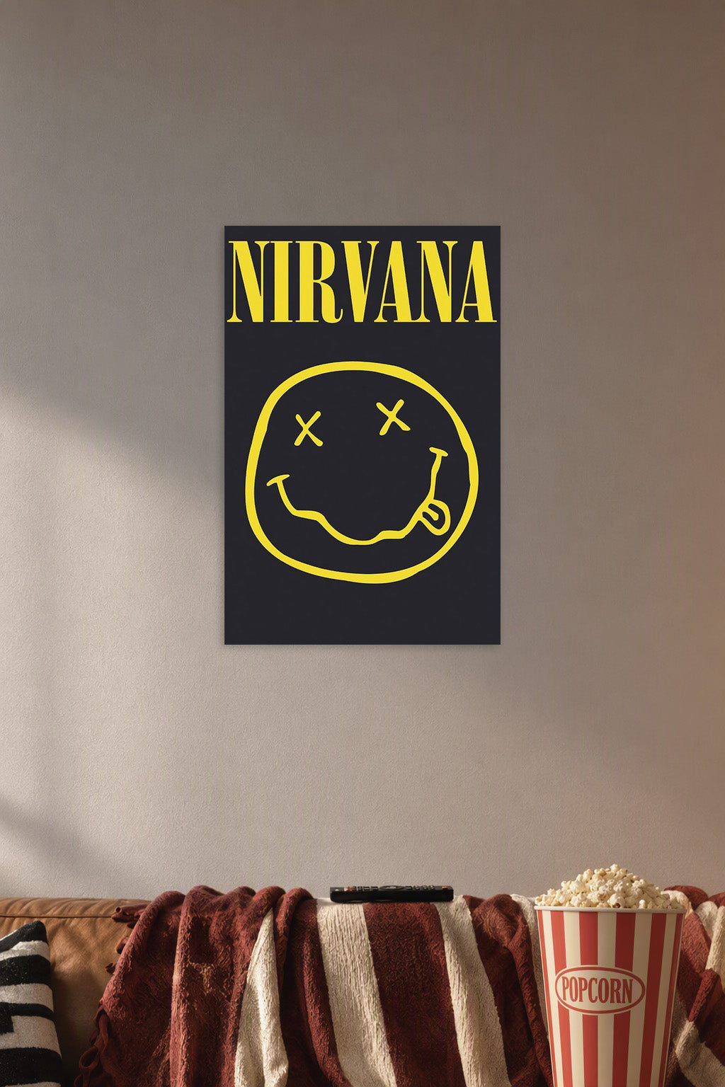 Nirvana Smiley Logo in a cozy movie room above a brown sofa with popcorn.
