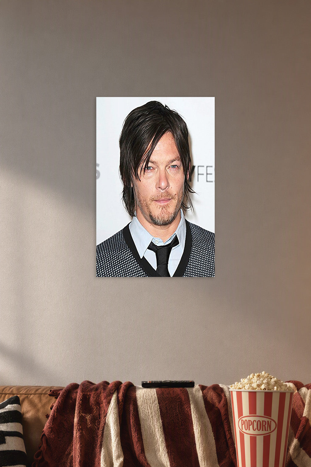 Norman Reedus in a cozy movie room above a brown sofa with popcorn.