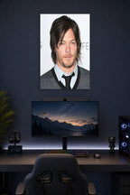 Norman Reedus in a gaming desk setup above a monitor.